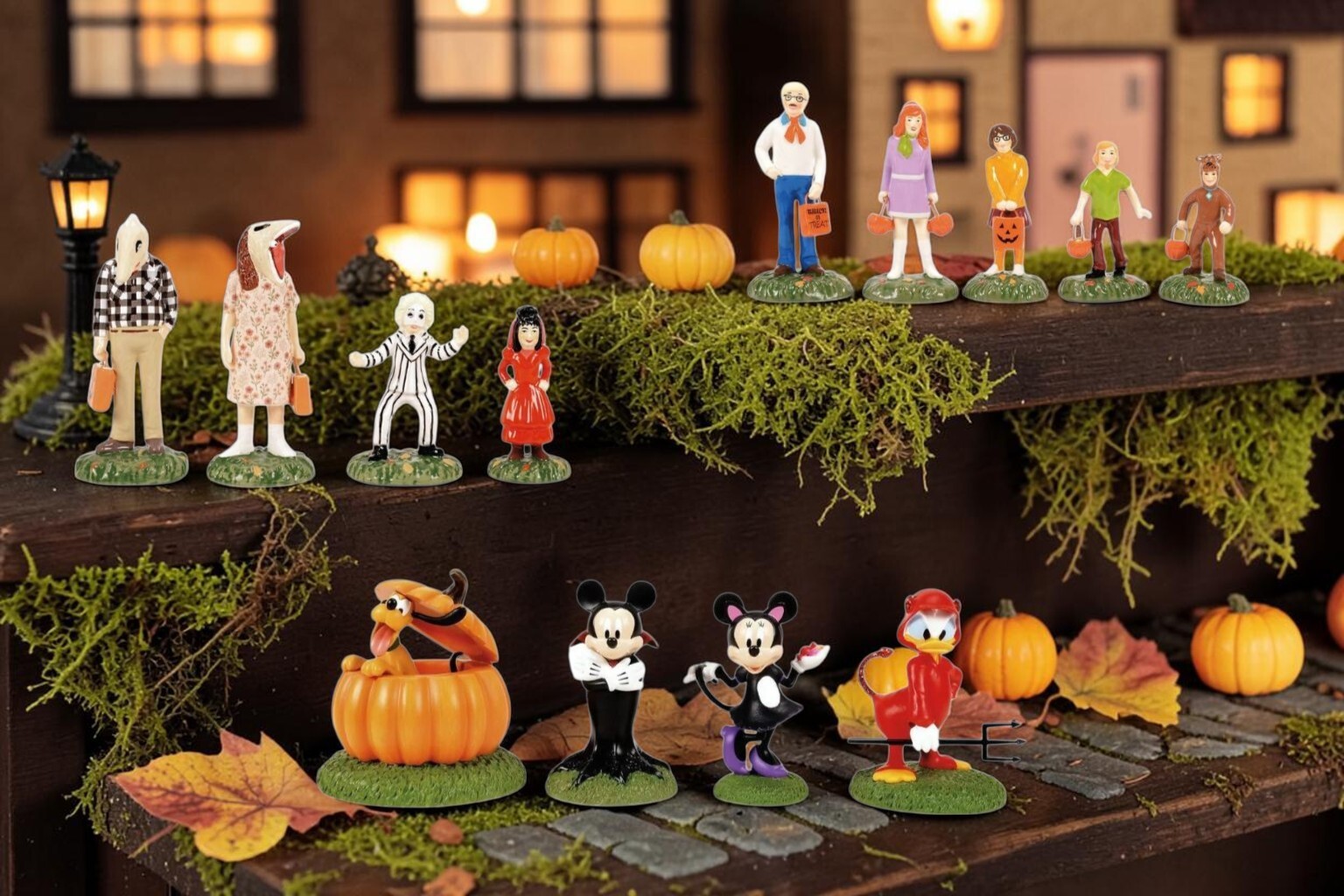 Halloween village lit with string lights tucked behind buildings to fill the dark gaps between them